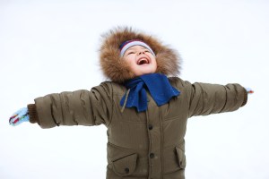 child in a snow suit happy